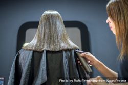 Hair stylist trimming ends of female customer 5lyBa4