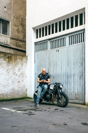 Biker looking mobile sitting on motorcycle