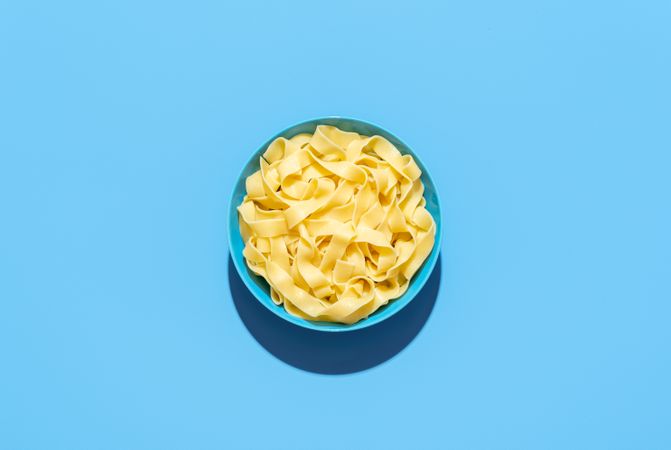 Pappardelle pasta bowl isolated on a blue background