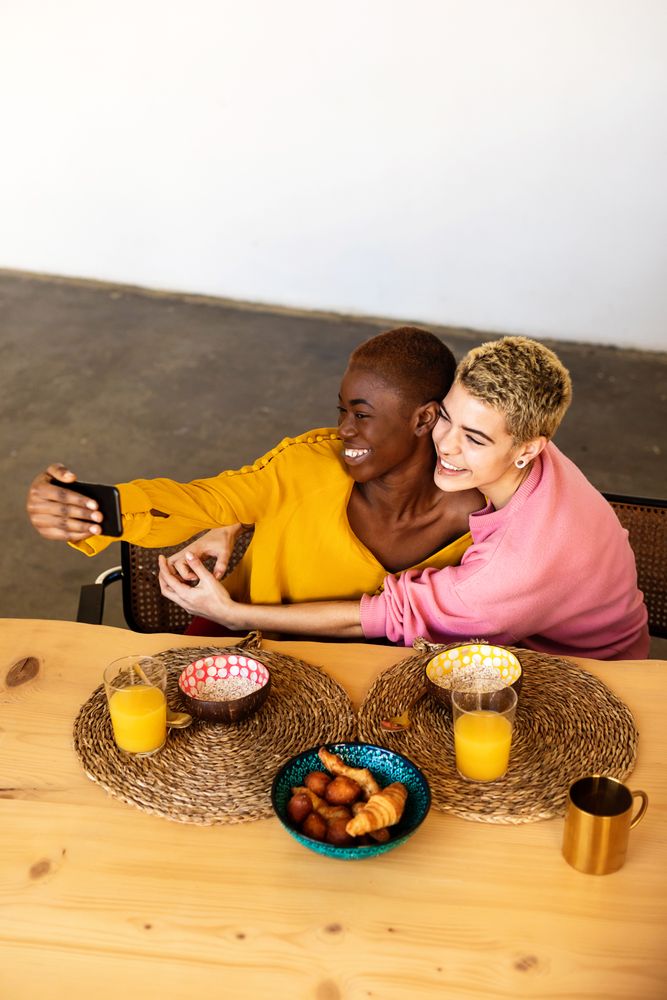 Two girlfriends having breakfast together at home