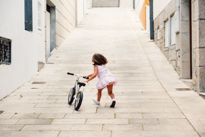 Girl riding on bicycle in narrow street