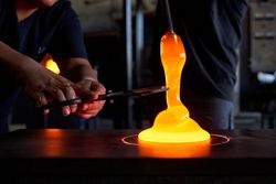Unrecognizable men cutting liquid glass in workshop
