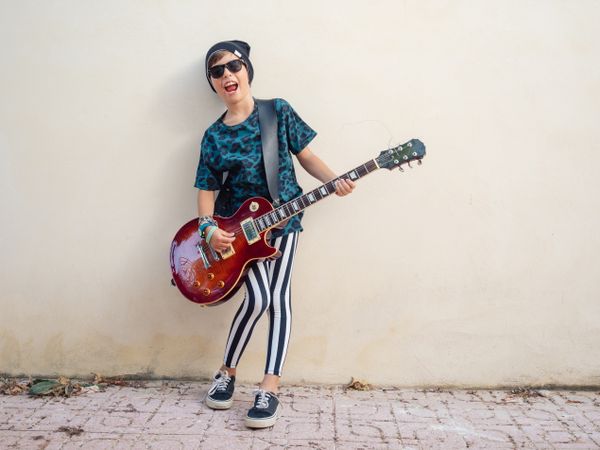 Energetic kid holding guitar