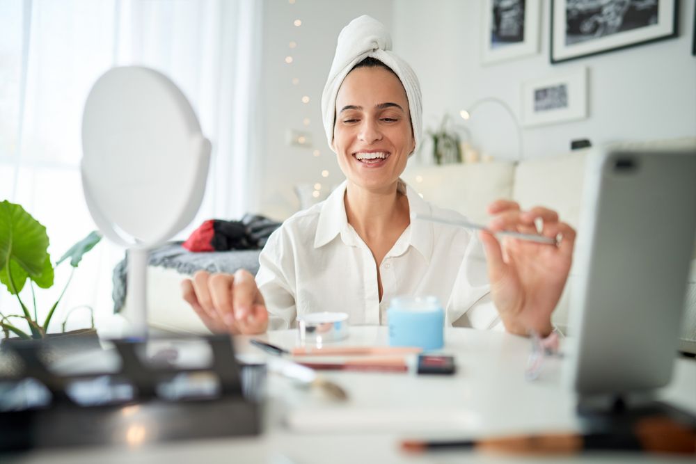 Cheerful woman recording beauty blog on smartphone