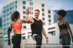 Female athlete giving high five to a man after fitness training standing on rooftop 56ZaP5