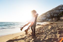 Woman jumps into man’s arms on the beach