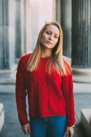 Stylish female standing near marble columns