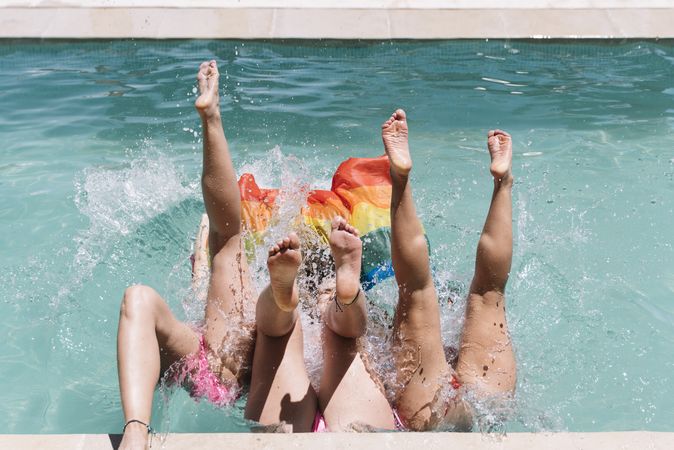 Anonymous lesbians splashing in swimming pool