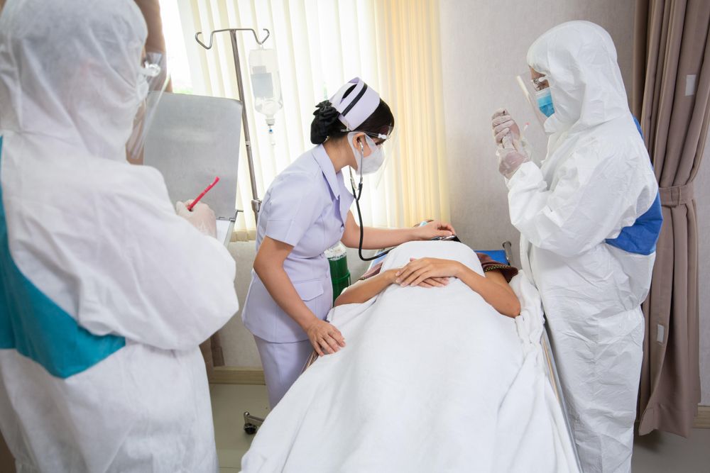 Patient in hospital bed surrounded by doctors and nurse