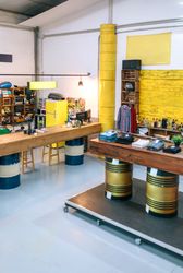 Interior of empty clothing store with clothes on counter over fuel barrels and industrial style