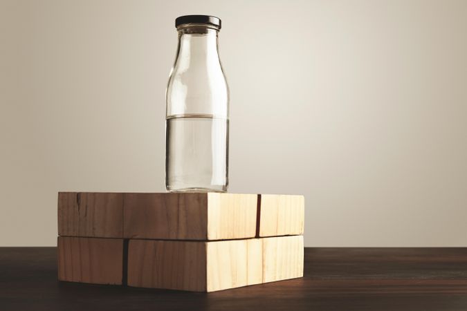 Bottle filled with water on wooden blocks