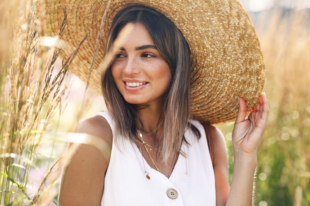 Woman in field wearing a large straw hat