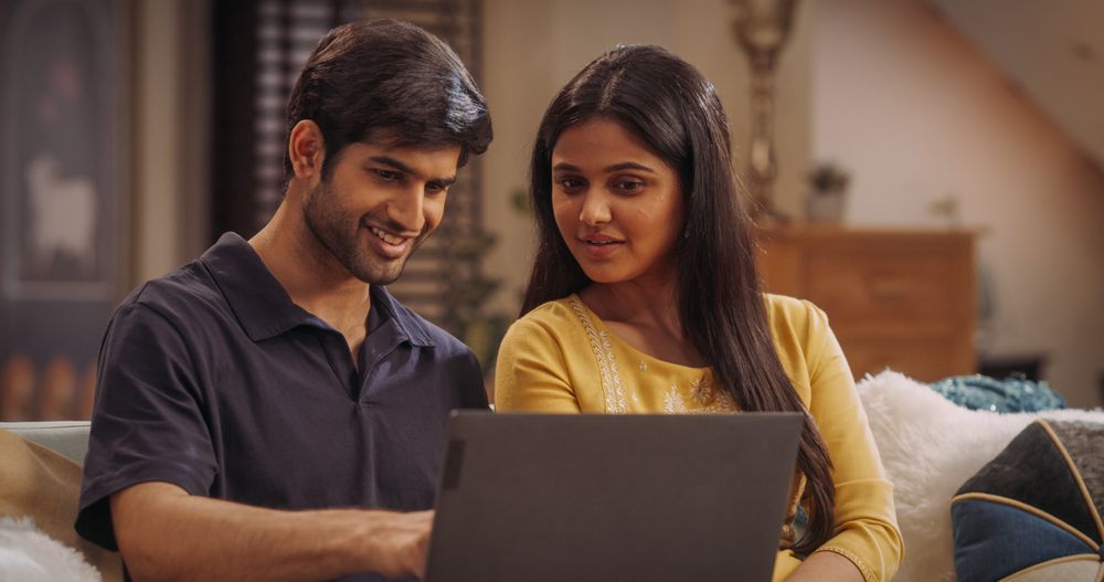 Enthusiastic Indian couple browsing online stores for fashionable outfits, latest electronics, or exclusive travel offers.