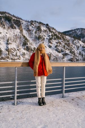 Woman enjoying landscape of river and snowy mountains