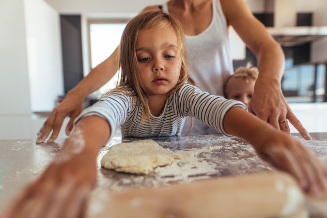Little girl learning cooking and baking with flour and a rolling pin