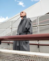 Stylish young man looking off in the distance on walkway