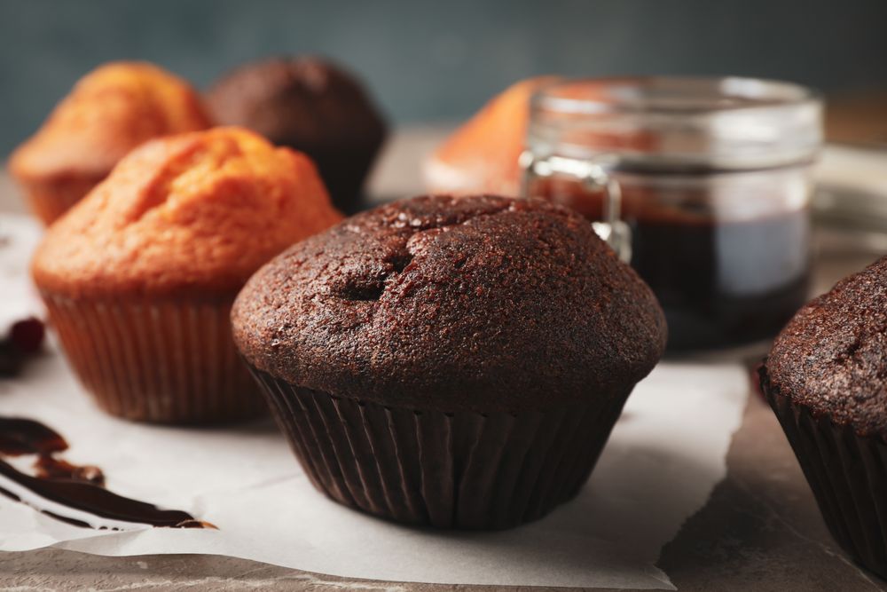 Composition with delicious muffins, berries, chocolate and baking paper