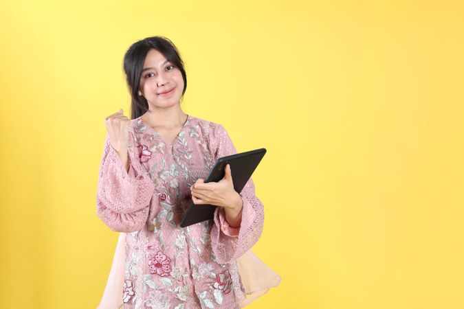 Happy Asian Woman with Indonesian Kebaya using Tablet Phone