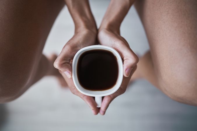 Faceless woman with coffee cup in hands