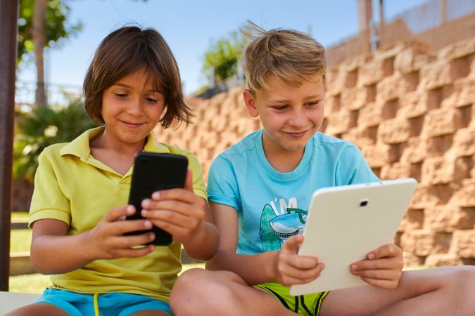 Boys using tablet in garden