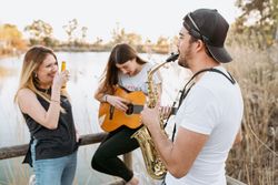 Drunk woman listening to friends playing musical instruments