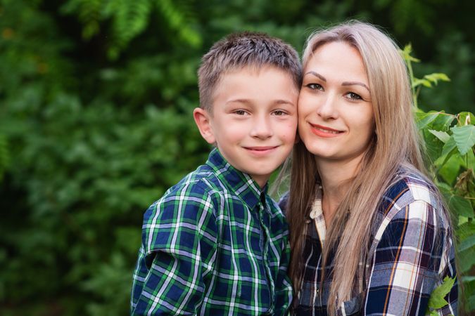 Portrait of blonde mother spending time with son in backyard