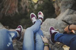 Casual couple resting together while sitting on high cliff