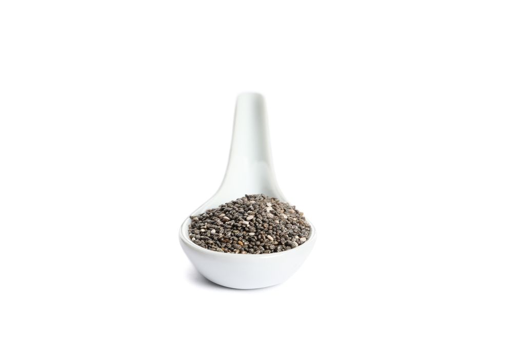 Chia seeds in porcelain spoon isolated on plain background
