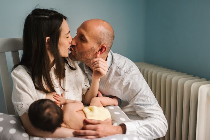 Happy parents feeding baby