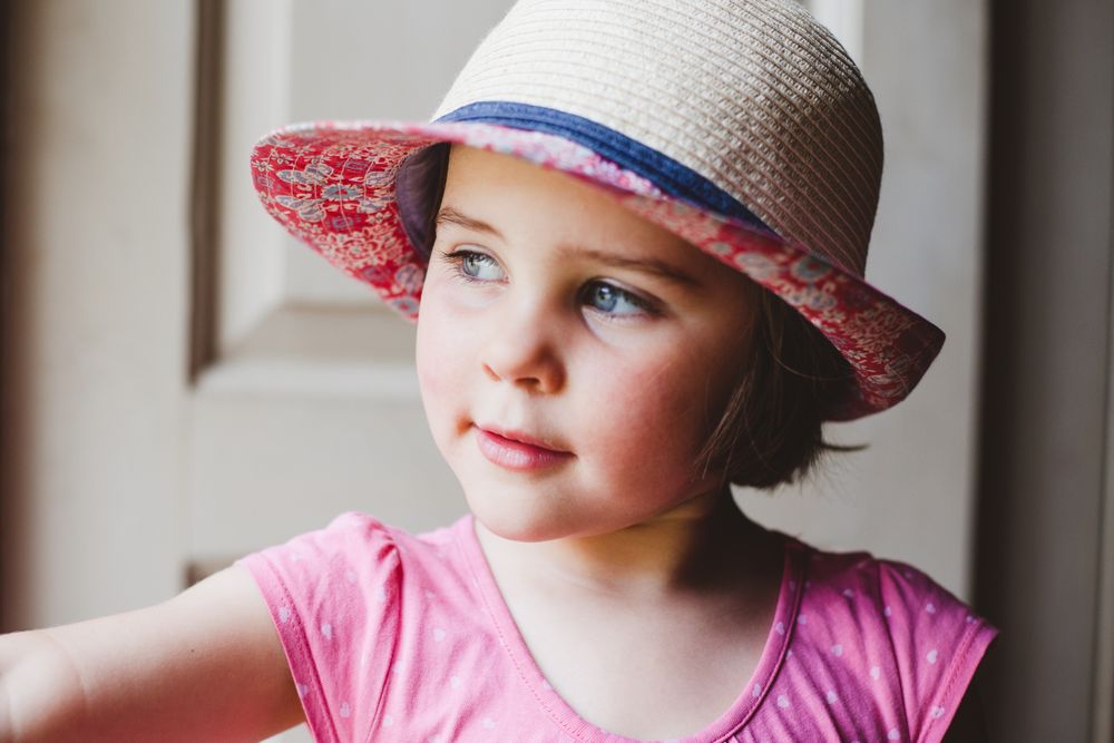 Portrait of girl in pink tank top wearing hat