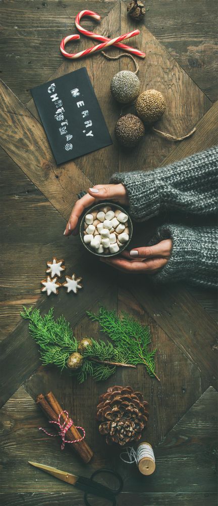 Homely holiday with “Merry Christmas” card, woman with hot chocolate, vertical composition
