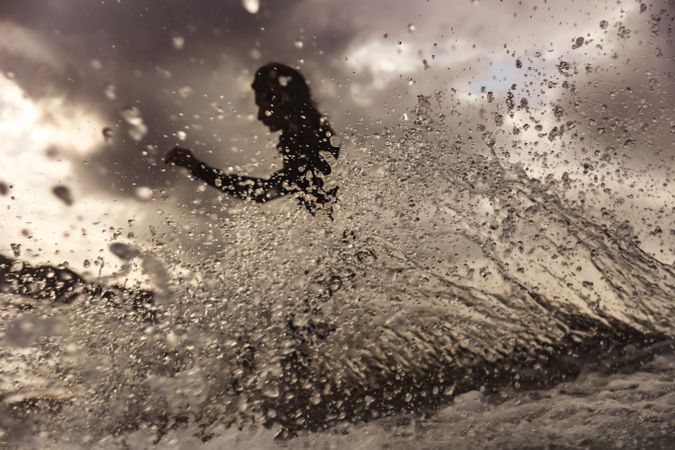 Woman on surf board floating on water between splashes