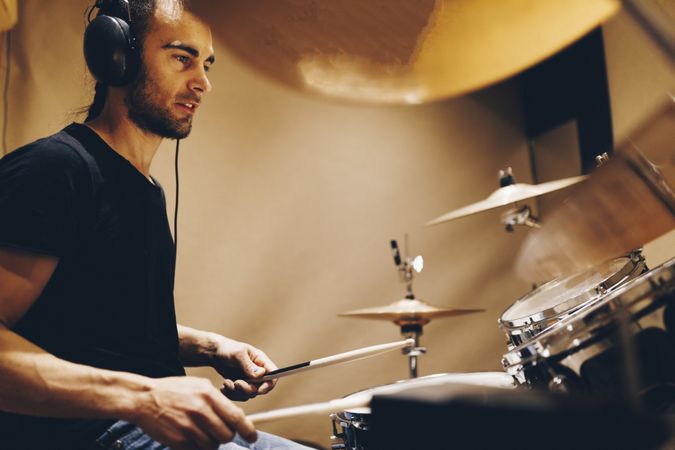 Man with headphones playing on drums