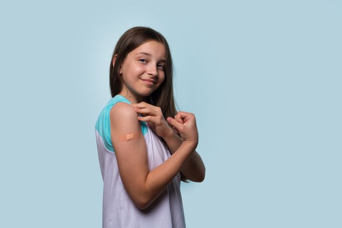 Girl shows off her vaccinated arm by flexing