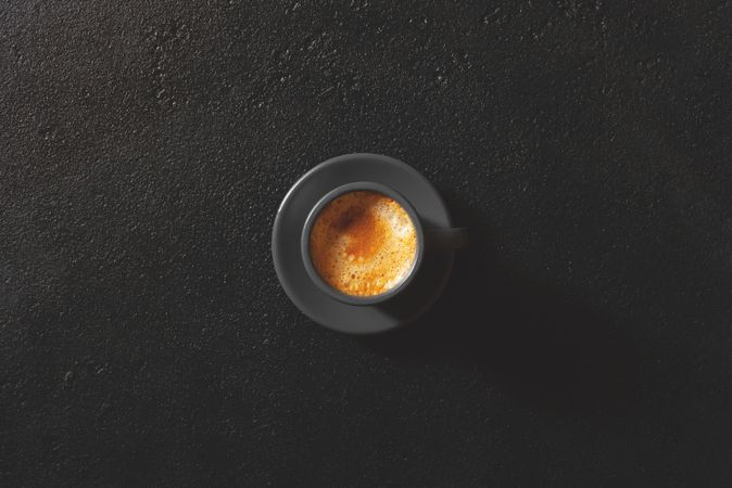 Top view of espresso coffee with milk on minimal dark background