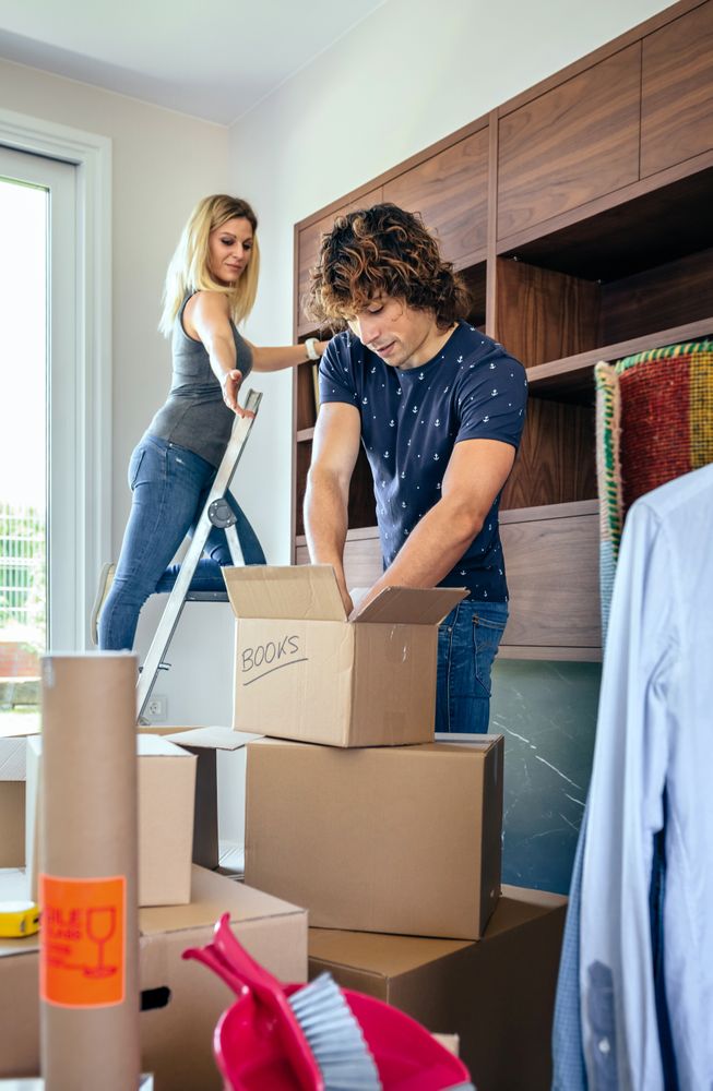 Couple unpacking boxes and placing books