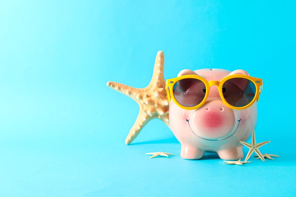 Happy piggy bank with sunglasses and starfishes on color background, space for text. Finance, saving money