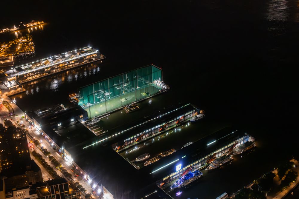 Aerial View with Private Docks with Luxury Boats and Yachts. Panorama of the Area from a Helicopter, Showing Residential and Industrial Buildings. Harbour Area with Ship and Loading Equipment