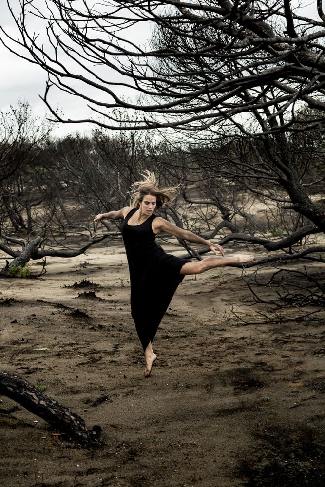 Woman dancing between dry trees