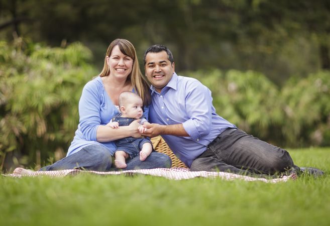 Happy Family Sitting In The Park