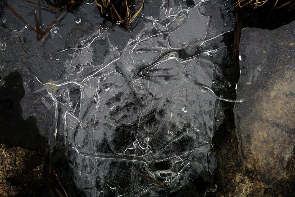 Fragment of thin ice on dark frozen river