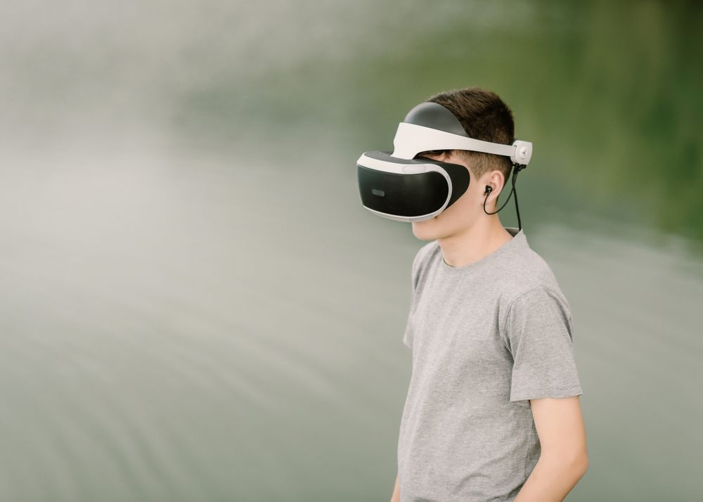 Young teenager with virtual reality glasses outdoors