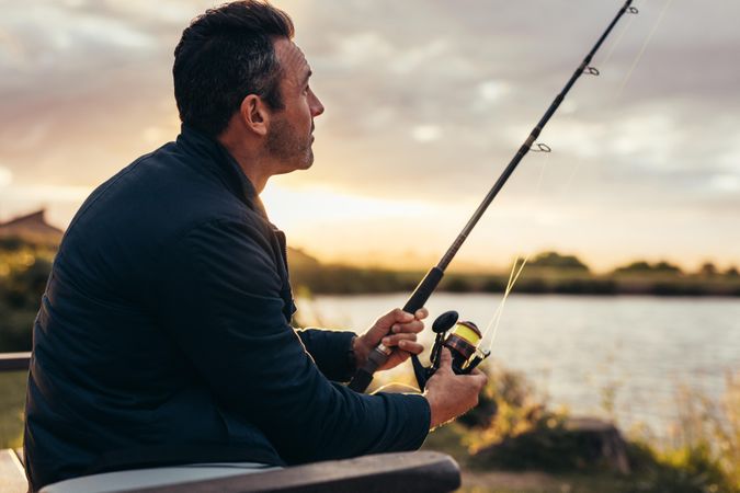 Side view of a fisherman enjoying his leisure time fishing