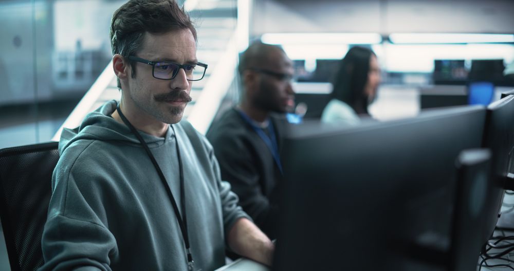 Portrait of a Thoughtful Engineer Working on Desktop Computer in a Technological Office Environment.