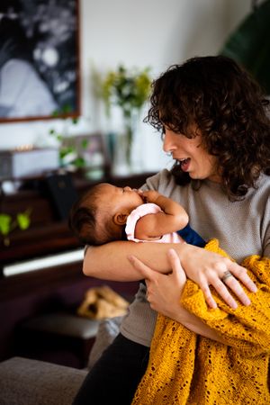 Woman coddling newborn, vertical