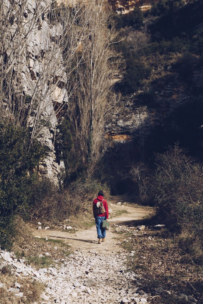 Traveling woman on road in rocky cliffs