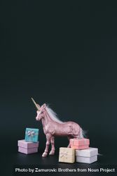 Pink glitter unicorn with wrapped presents on dark background 0VzlD0