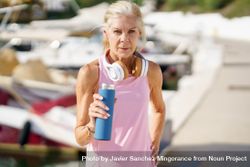 Mature female with grey hair drinking between exercise 4MmMq4