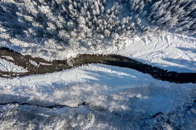 Aerial view with river in the snow-covered nature in the Bavarian mountains, Germany
