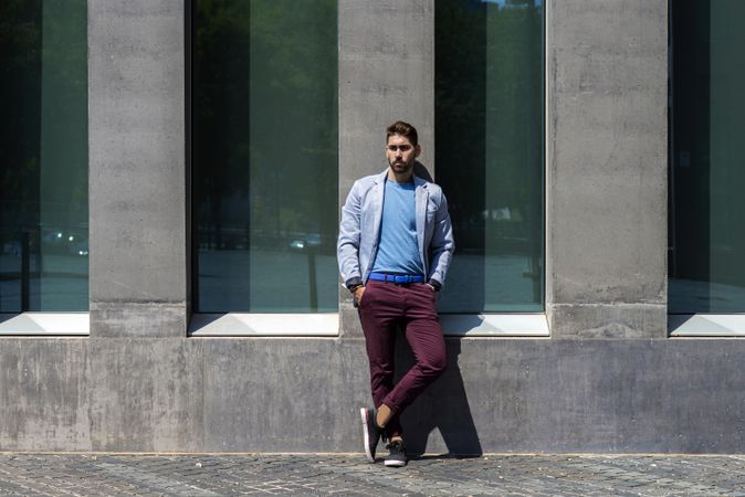 Man leaning on wall outside in the sun